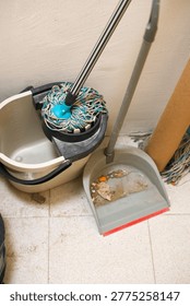Cleaning process after renovation with tools and debris in interior. Indoor cleaning after renovation with tools, gloves, mop and debris. Post-construction cleanup process in a room with maintenance equipment and work in progress.
