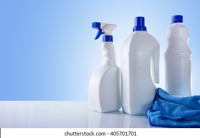 Cleaning products on white table and blue background overview. Front view. Horizontal composition. - Powered by Shutterstock