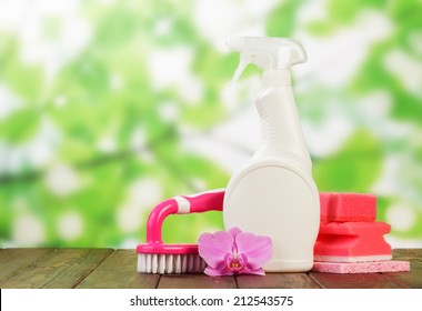 Cleaning products and pink flower on outdoor table - Powered by Shutterstock