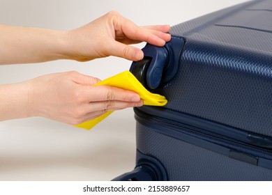 Cleaning The Rubber Wheels Of A Travel Suitcase With A Yellow Rag From Dust And Dirt. Luggage Care.