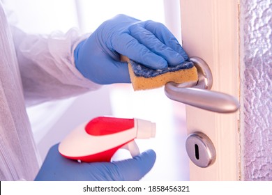 Cleaning And Sanitizing Door Handle In Hotel Room With Blue Gloves During Covid19 Coronavirus Pandemic.