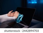 Cleaning the screen of laptop computer with microfiber cloth by hand