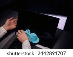 Cleaning the screen of laptop computer with microfiber cloth by hand