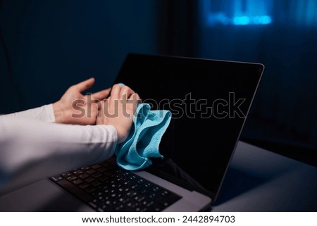 Cleaning the screen of laptop computer with microfiber cloth by hand