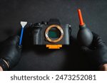 Cleaning the sensor of a photo camera. Male hands in rubber gloves hold a camera sensor maintenance kit. 