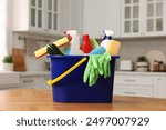 Cleaning service. Bucket with supplies on table in kitchen