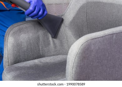 A Cleaning Service Worker Cleans The Office Chair With A Washing Vacuum Cleaner