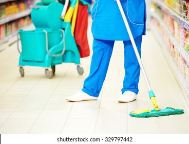 Cleaning Services. Female Cleaner In Uniform  With Mop The Floor In Supermarket Shop Store