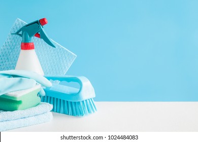 Cleaning set for different surfaces in kitchen, bathroom and other rooms. Empty place for text or logo on blue background. Cleaning service concept. Early spring regular clean up. Front view. - Powered by Shutterstock