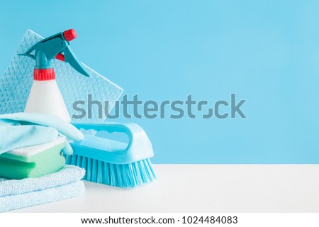 Cleaning set for different surfaces in kitchen, bathroom and other rooms. Empty place for text or logo on blue background. Cleaning service concept. Early spring regular clean up. Front view.