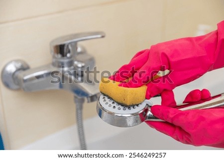 Cleaning the Showerhead using a Sponge and Wearing Gloves for Better Hygiene and Care