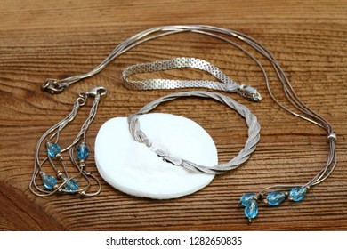 Cleaning Silver Jewellery With Baking Soda. Alternative Cleaning Woman Jewellery Concept, Brown Wooden Board