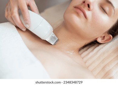 Cleaning skin by ultrasound skin cleaning appliance to a young girl. Modern cosmetological device for ultrasound skin cleaning - Shutterstock ID 2348348729