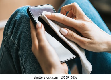 Cleaning the smartphone screen with a fiber cloth from dirt dust and other external factors. Mobile Care Concept - Powered by Shutterstock