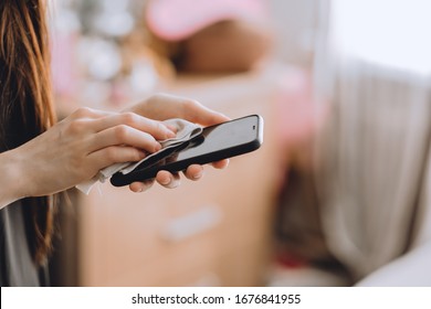 Cleaning the smartphone screen with a fiber cloth from dirt dust and other external factors. Germs elimination. Mobile Care Concept - Powered by Shutterstock