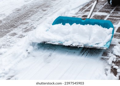 Cleaning snow from sidewalk and using snow shovel