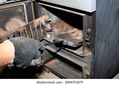 Cleaning The Solid Fuel Boiler From The Remains Of Firewood And Coal. Boiler With An Open Damper. Heating Efficiency In The House.