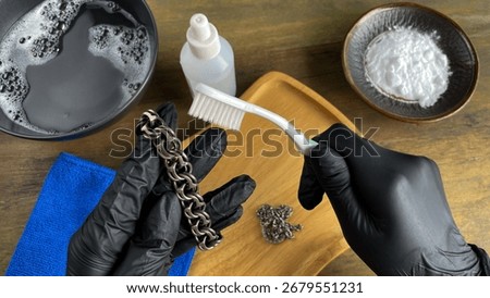 Cleaning a solid silver bracelet at home. Baking soda, soapy water, and a brush help remove tarnish and restore the jewelry's shine.