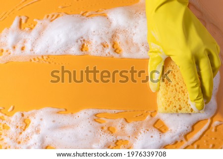 Cleaning sponge with soap. Texture with bubble suds on yellow background. copy space. Housekeeping cleaning with sponge.