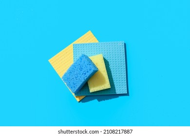 Cleaning sponges and rags on blue background