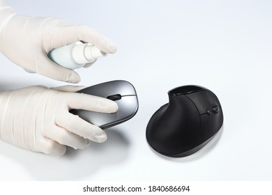 Cleaning Staff Clean Wireless Mouse In Office Or School With Alcohol Spray. Corona Virus Or Bacteria Infected Protection From Touching Public Object. 