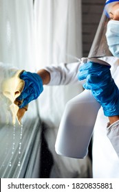 Cleaning staff disinfecting the house against virus, wearing transparent protective mask - Shutterstock ID 1820835881