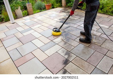 Cleaning stone slabs on patio with the high-pressure cleaner. Person worker cleaning the outdoors floor. clean and dirty - Shutterstock ID 2027002511