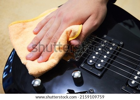 Cleaning the strings and deck of the guitar. Care and maintenance of musical instruments