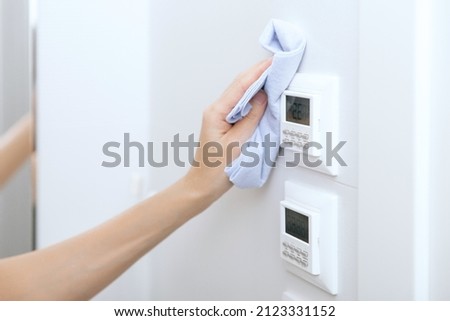 Cleaning switches and sockets with a microfiber cloth. Woman hand using wet wipe for cleaning home room door link. Sanitize surfaces prevention in hospital and public spaces against corona virus. Foto stock © 