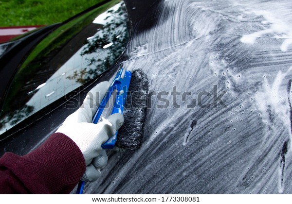 cleaning the tarpaulin roof top  of the\
convertible with foam\
cleaner.
