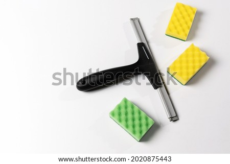 cleaning tools, scraper, window nozzle and colored washcloths on a white background