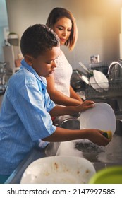 Cleaning Until The Dishes Are Spotless. Shot Of A Mother And Son Washing Dishes Together.