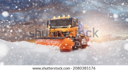 A cleaning vehicle clears the snow from the street - onset of winter