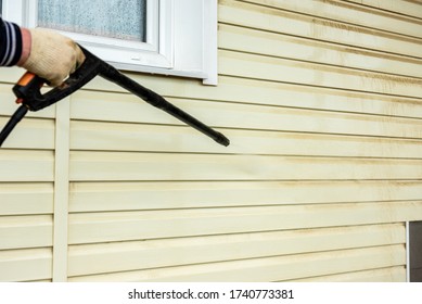 Cleaning The Vinyl Siding Wall With A High-pressure Washer.