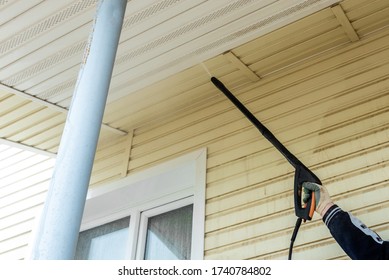 Cleaning The Vinyl Siding Wall With A High-pressure Washer.