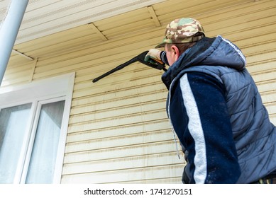 Cleaning The Vinyl Siding Wall With A High-pressure Washer.