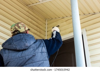 Cleaning The Vinyl Siding Wall With A High-pressure Washer.