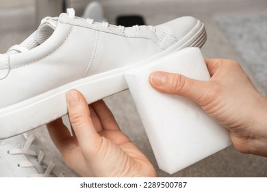 Cleaning white shoes and soles from dust and dirt with a melamine sponge