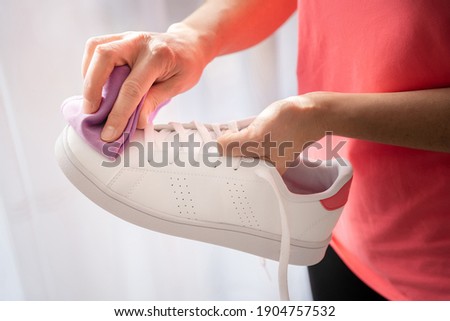 Cleaning white sneaker with purple cloth