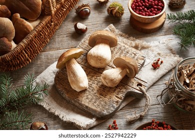 Cleaning wild king bolete or porcini mushrooms on a wooden table in autumn - preparation for drying