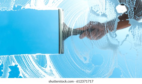 cleaning window with squeegee blue sky - Shutterstock ID 612371717