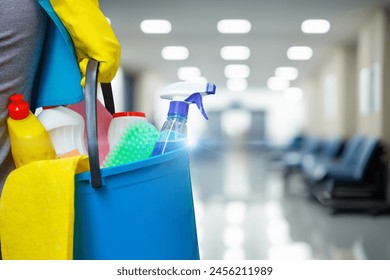 Cleaning woman with bucket and cleaning supplies on blurred background of hospital or office corridor. - Powered by Shutterstock