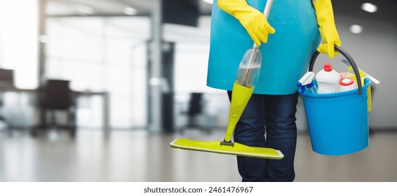 Cleaning woman with mop and cleaning supplies standing on blurred office background. - Powered by Shutterstock