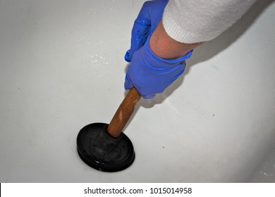 A Cleaning Woman Trying To Repair A Clogged Bath Tub. White Background.