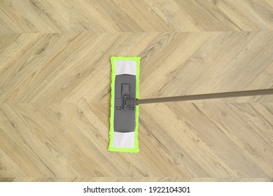 Cleaning of wooden floor with mop, top view