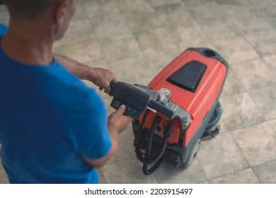 A Cleaning Worker Turns On The Machine To Wash The Hard Floor