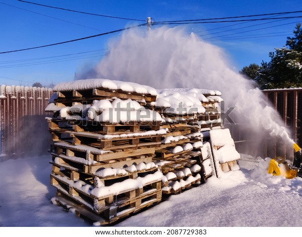 Cleaning the yard with snow blower in winter,\
seasonal activity.