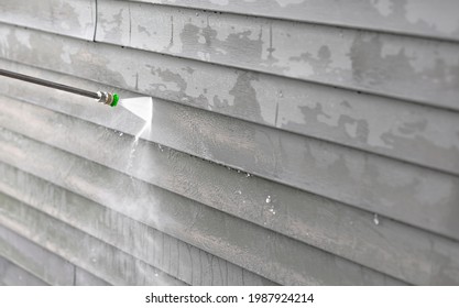 Cleansing Dusk And Dirt From Exterior Siding By High Pressure Nozzle Spray With Water Soap Cleaner, Weekend Chore. Washer Machine Of Cleansing House. Clean Outside Wall Of House, Maintenance Concept.