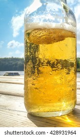 Clear beer bottle on wooden lakeside dock