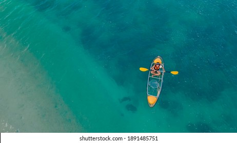 Clear Blue Sea With Floating Transparent Kayak, Person With Life Jacket On Boat